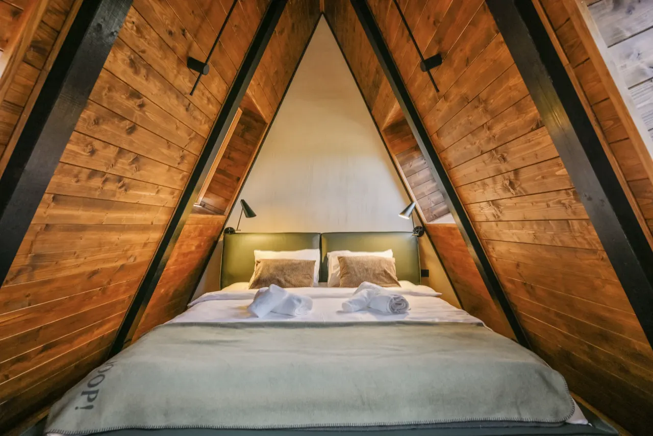 Attic bedroom tucked symmetrically under the exposed timber ridge