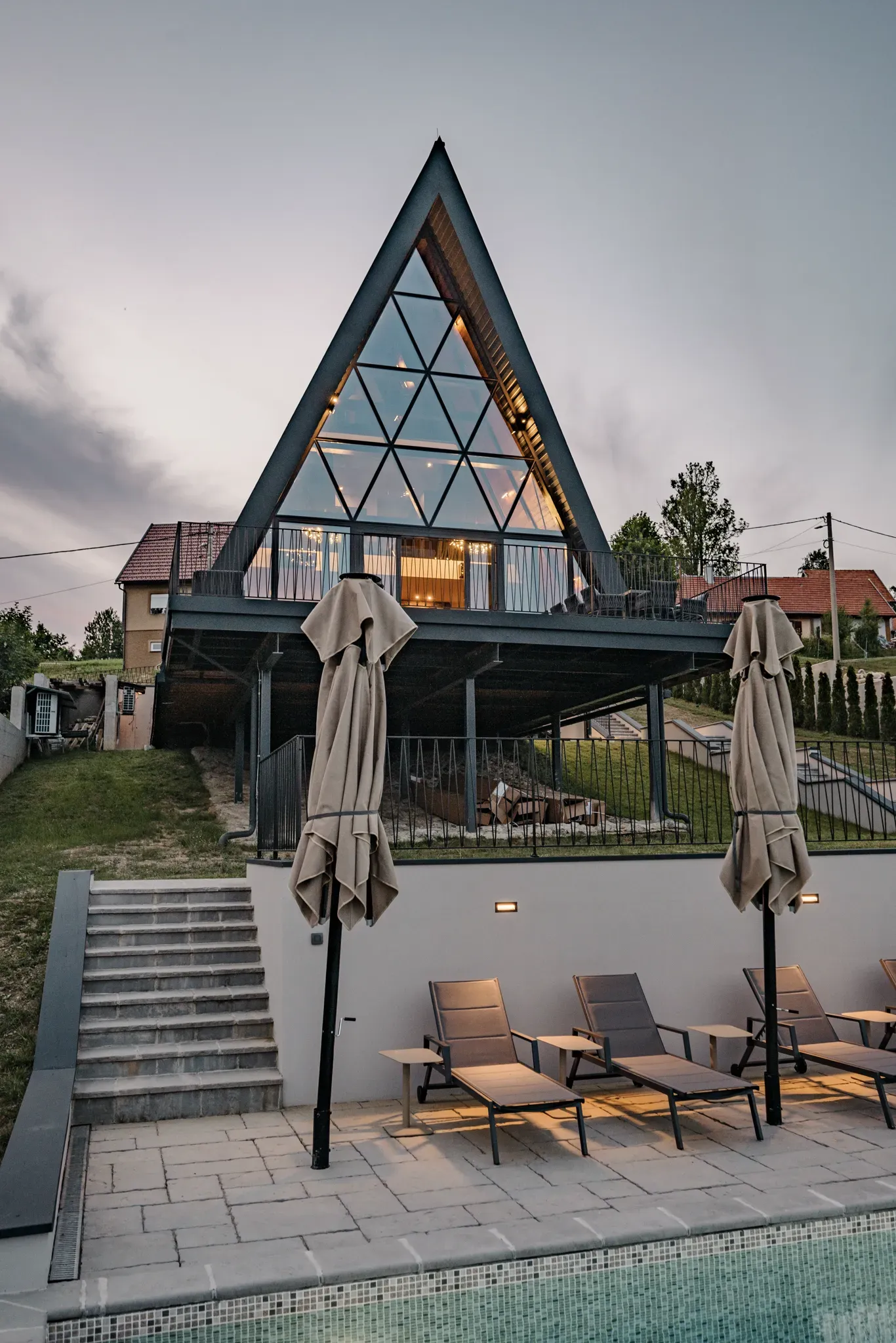 A-frame vila The Frame osvijetljena u sumrak iznad bazena